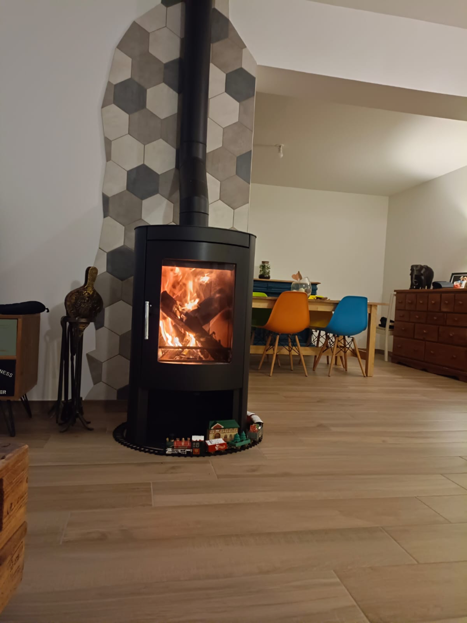 Salon rénové avec poêle à bois et sol en chêne clair.